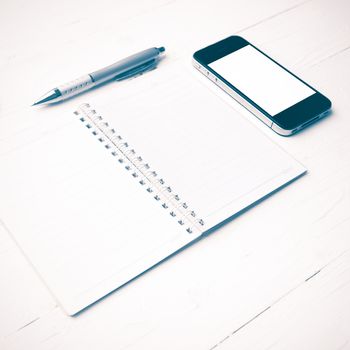cellphone with notepad and pen over white table vintage style