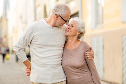 family, age, tourism, travel and people concept - senior couple hugging on city street