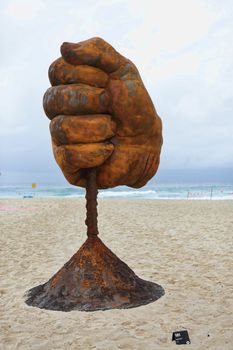 BONDI, AUSTRALIA - OCTOBER 22, 2015;  Annual Sculpture by the Sea free public event.  Exhibit titled  Dust by Norton Flavel.  Weathered steel fist.