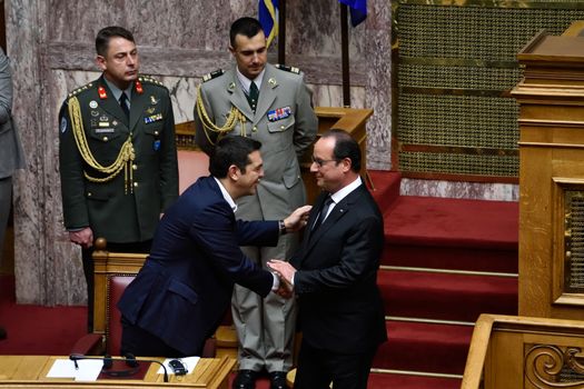 GREECE, Athens: French President Francois Hollande (R) shakes hands with Greek Prime Minister Alexis Tsipras (L) after delivering a speech during the plenary session of the Greek Parliament, on the second day of his visit to Athens, on October 23, 2015.