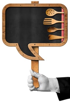 Hand of chef holding a pole with empty blackboard in the shape of speech bubble with four wooden kitchen utensils. Isolated on white background 