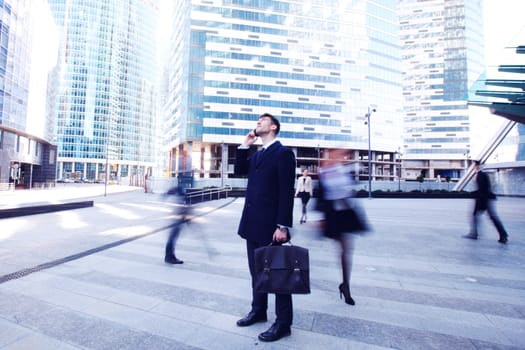 Handsome businessman talking on the cellphone outside office building