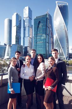 Portrait of business team outside office on skyscrapers background