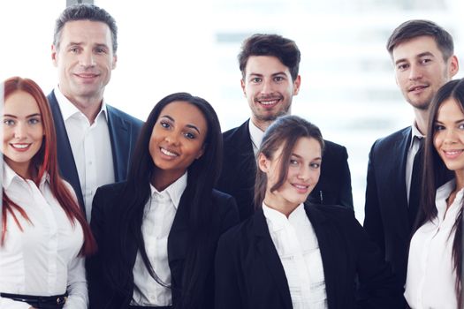 Portrait of business team of men and women in office with view on skyscrapers