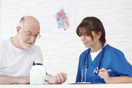 Doctor measuring blood pressure of male senior patient