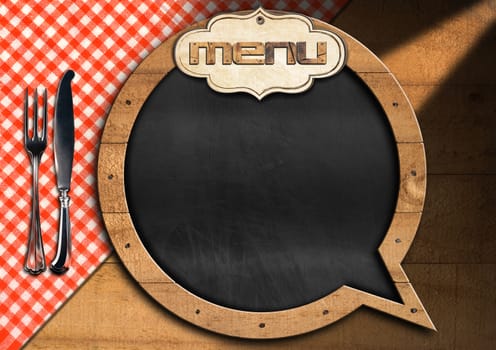 Restaurant menu with empty blackboard in the shape of speech bubble on a wooden background with silver cutlery and checkered tablecloth