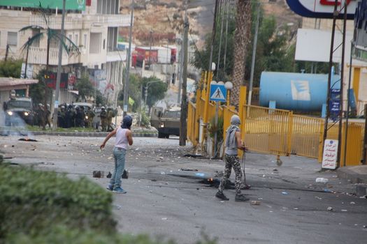 WEST BANK, Hebron: Young Palestinian protesters face Israeli security forces during clashes on October 23, 2015, following Friday prayers in Ras e-Jura, in the northern entrance of Hebron, West Bank. Israel lifted age restrictions for the main weekly prayers at Jerusalem's flashpoint Al-Aqsa mosque compound, in an apparent bid to ease tensions over the site that sparked a surge in Israel-Palestinian violence. 