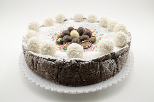 Easter cake with ricotta and chocolate decorated with chocolate eggs and powdered sugar