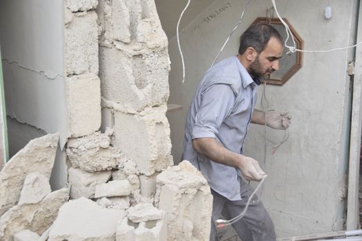 SYRIA, Harasta: This picture shows a man walking through the rubble in the the Syrian town of Harasta on October 23, 2015 following a series of recent airstrikes. The Syrian army launched an offensive in the area which targeted various rebel opposition. In addition to airstrikes, the Syrian army also launched a ground operation in the region.