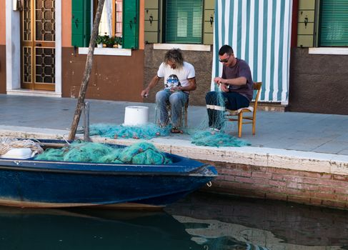 VENICE, ITALY CIRCA SEPTEMBER 2015: Fishermen repair their nets after a night of fishing.