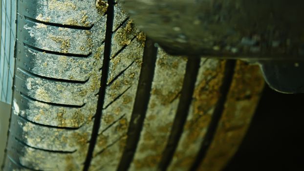 detail of a car wheel and some mud tainting the car