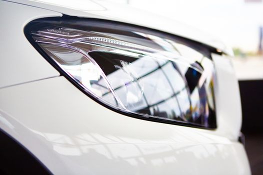 Detail on the headlight of a white car