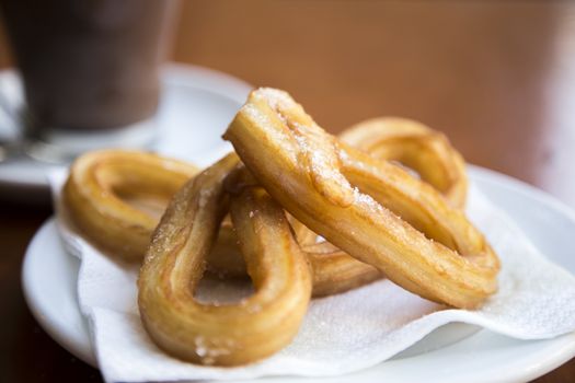 Spanish Churros with hot chocolate in background