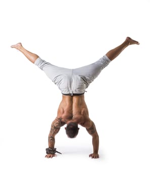 Muscular Shirtless Male Acrobatic Dancer Balancing on Arm and Hand in Studio Isolated on White Background