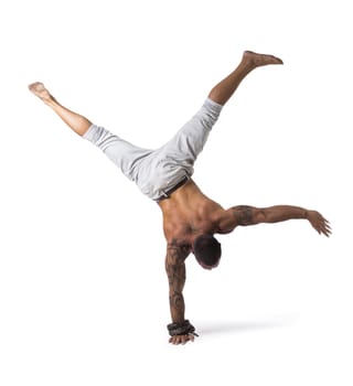 Muscular Shirtless Male Acrobatic Dancer Balancing on Arm and Hand in Studio Isolated on White Background