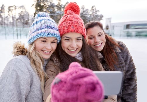 people, friendship, technology, winter and leisure concept - happy teenage girls taking selfie with smartphone outdoors