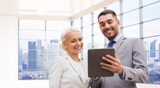 business, partnership, technology and people concept - smiling businessman and businesswoman with tablet pc computer over office room or new apartment background