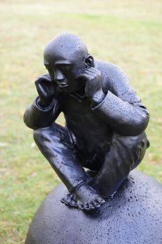 BONDI, AUSTRALIA - OCTOBER 22, 2015;  Annual Sculpture by the Sea free public event.  Exhibit titled Man on Ball - a collection of painted bronze statues on squatting on balls each with expressive features