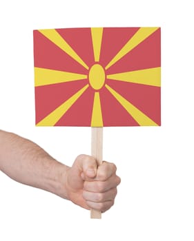 Hand holding small card, isolated on white - Flag of Macedonia