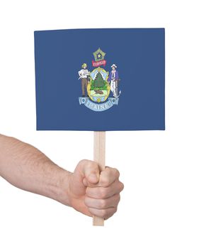 Hand holding small card, isolated on white - Flag of Maine