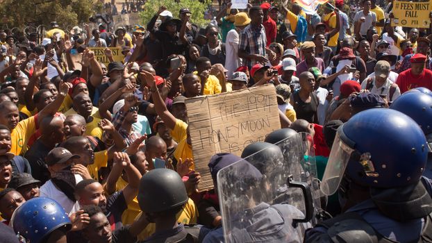 SOUTH AFRICA, Pretoria: Demonstrators run from police as an estimated 10,000 people gather at the Union Buildings on October 23, 2015.  The protesters demand that proposed tuition fee rises be scrapped, and called for the president, Jacob Zuma, to personally address their concerns.  It was the largest student protest since the 1976 Soweto uprising, a significant moment in the fight against South Africa's apartheid regime. 
