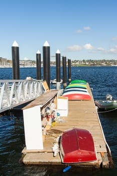 Colorful rowboats on a dock with a fireboat in the background