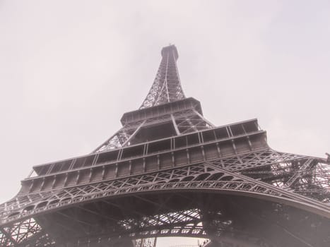 Closeup picture of the Eiffel Tower in Paris, France, surrounded with fog.