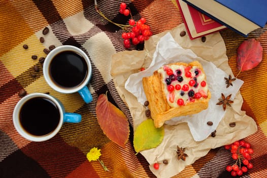 Romantic autumn still life with blanket, cake, book, coffee cups and leaves, top view