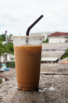Ice milk tea, famous drink on old wood table, City background