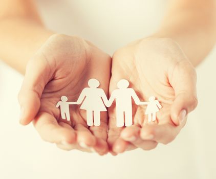 close up of womans cupped hands showing paper man family