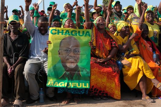 TANZANIA, UNITED REPUBLIC OF, Dar es Salaam : A man holds up a poster of presidential candidate John Magufuli during a ruling Chama Cha Mapinduzi (CCM) rally in Dar es Salaam, Tanzania, on October 21, 2015. CCM's party's candidate John Magufuli hopes to succeed President Jakaya Kikwete in what is seen as the tightest electoral race in Tanzania's history, as the main opposition parties unite around ex-prime minister Edward Lowassa, 61, who recently defected from the CCM. 