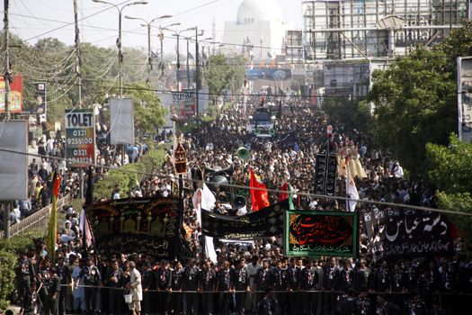 PAKISTAN, Karachi : Shiite Muslims pray during a Ashura procession to commemorate the martyrdom of Imam Hussain, the grandson of Prophet Muhammad, in Karachi on October 24, 2015. The Islamic month of Muharram marks the seven-century martyrdom of Prophet Mohammad's grandson Imam Hussein who was killed in battle in Karbala in Iraq 680 AD. 