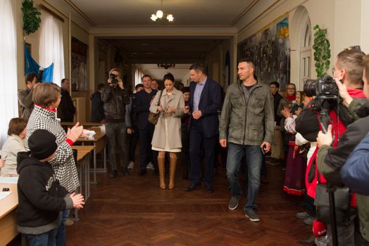 UKRAINE, Kiev: Kiev's mayor Vitaly Klitschko, his wife Natalia, and brother Vladimir Klitschko prepare to cast their ballots at a polling station in Kiev on October 25, 2015. Ukrainians are voting in local elections to choose mayors and representatives to municipal councils in all parts of Ukraine except eastern areas controlled by Russian-backed separatists and in Russian-annexed Crimea. Polling stations are open across all Kiev-administered regions except for Mariupol. 