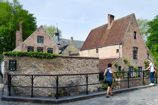 Bruges, Belgium - May 11, 2015: People around the Beguinage (Begijnhof) in Bruges, Belgium. Bruges is the capital and largest city of the province of West Flanders in the Flemish Region of Belgium.