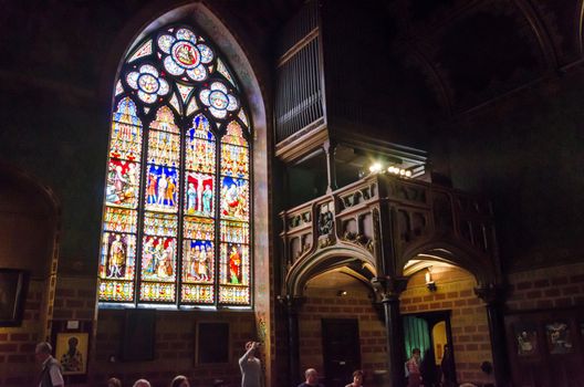 Bruges, Belgium - May 11, 2015: Tourists visit Interior of Basilica of the Holy Blood in Bruges, Belgium on May 11, 2015. Basilica is located in the Burg square and consists of a lower and upper chapel. 