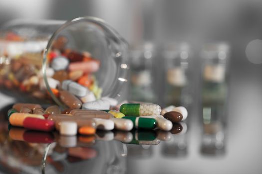 Colorful tablets with capsules and pills on background