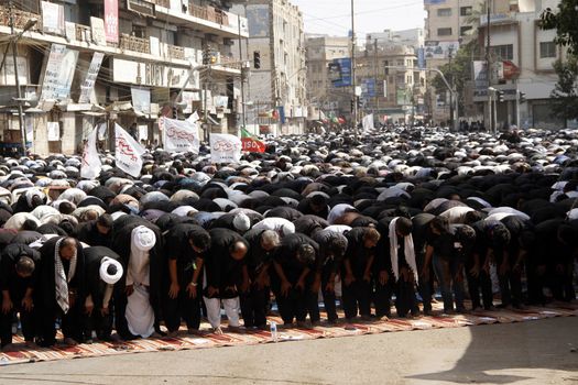 PAKISTAN, Karachi : Shiite Muslims pray during a Ashura procession to commemorate the martyrdom of Imam Hussain, the grandson of Prophet Muhammad, in Karachi on October 24, 2015. The Islamic month of Muharram marks the seven-century martyrdom of Prophet Mohammad's grandson Imam Hussein who was killed in battle in Karbala in Iraq 680 AD. 