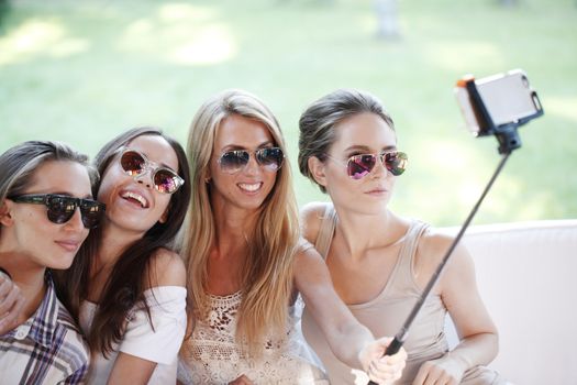 Young beautiful female friends taking selfie outdoors