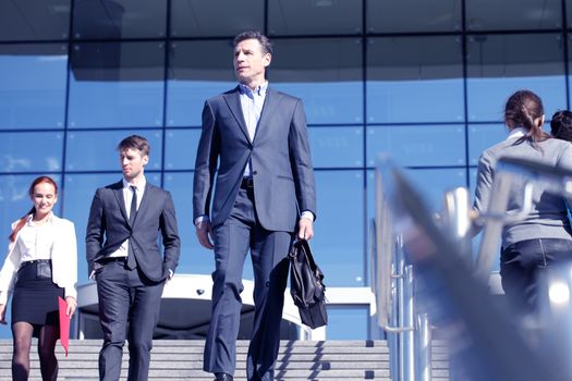 Team of diverse business people at stairs of company office building