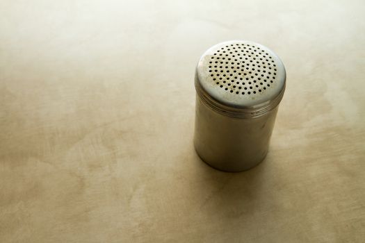 Used salt shaker sitting on the kitchen counter during cooking