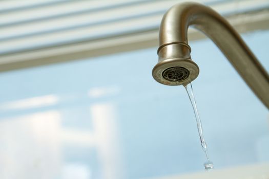 faucet with drops of water coming out of it