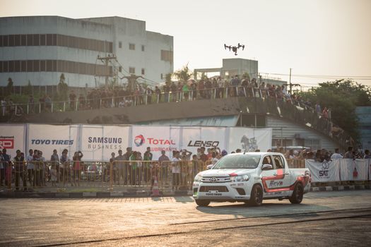 Udon Thani, Thailand - October 18, 2015: Techapol Toyingchareon the driver of Toyota Hilux Revo waving hand to the audiences after drifting contest on the track between driver from Thailand and Japan at the event Toyota Motor Sport show at Udon Thani, Thailand with broadcasting drone from above