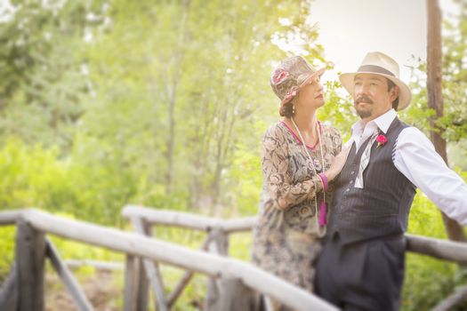 Attractive 1920s Dressed Romantic Couple on Wooden Bridge.