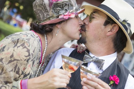 Attractive Mixed-Race Couple Dressed in 1920’s Era Fashion Sipping Champagne.