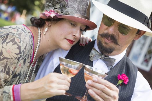 Attractive Mixed-Race Couple Dressed in 1920’s Era Fashion Sipping Champagne.