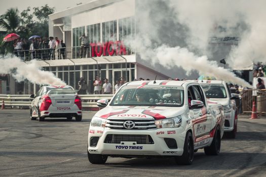 Udon Thani, Thailand - October 18, 2015: Toyota Hilux Revo perform drifting contest on the track between driver from Thailand and Japan at the event Toyota Motor Sport show at Udon Thani, Thailand with smoke in the background