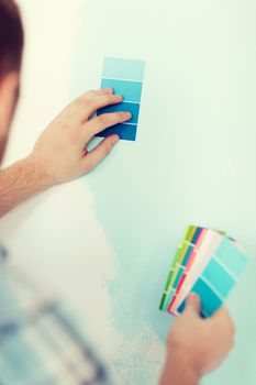 repair, building, technology and home concept - close up of male with color pallets choosing color