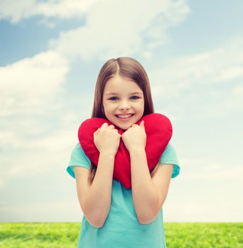 love, happiness and people concept - smiling little girl with red heart