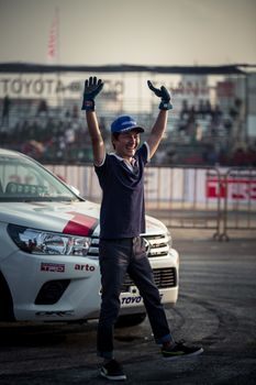 Udon Thani, Thailand - October 18, 2015: Masato Kawabata Japanese driver from Toyota Hilux Revo drifting contest between driver from Japan and Thailand waving hand to the audiences after the show