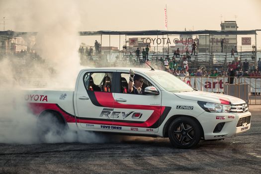 Udon Thani, Thailand - October 18, 2015: Techapol Toyingchareon the driver of Toyota Hilux Revo perform drifting contest on the track between driver from Thailand and Japan at the event Toyota Motor Sport show at Udon Thani, Thailand with  smoke of the burnout tires